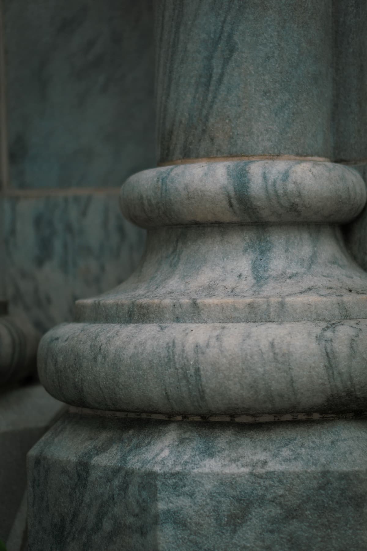 Detail of a polished marble column base with teal and grey veining